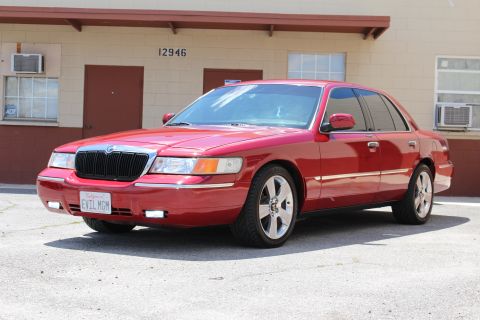 2002 Mercury Grand Marquis - A red 2002 Mercury Grand Marquis sedan is shown from a three-quarter front view.