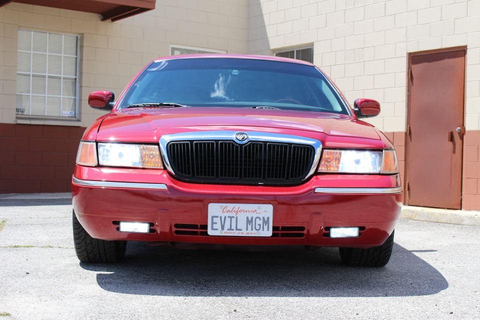 Red 2002 Mercury Grand Marquis with a black grille and "EVIL MGM" California license plate