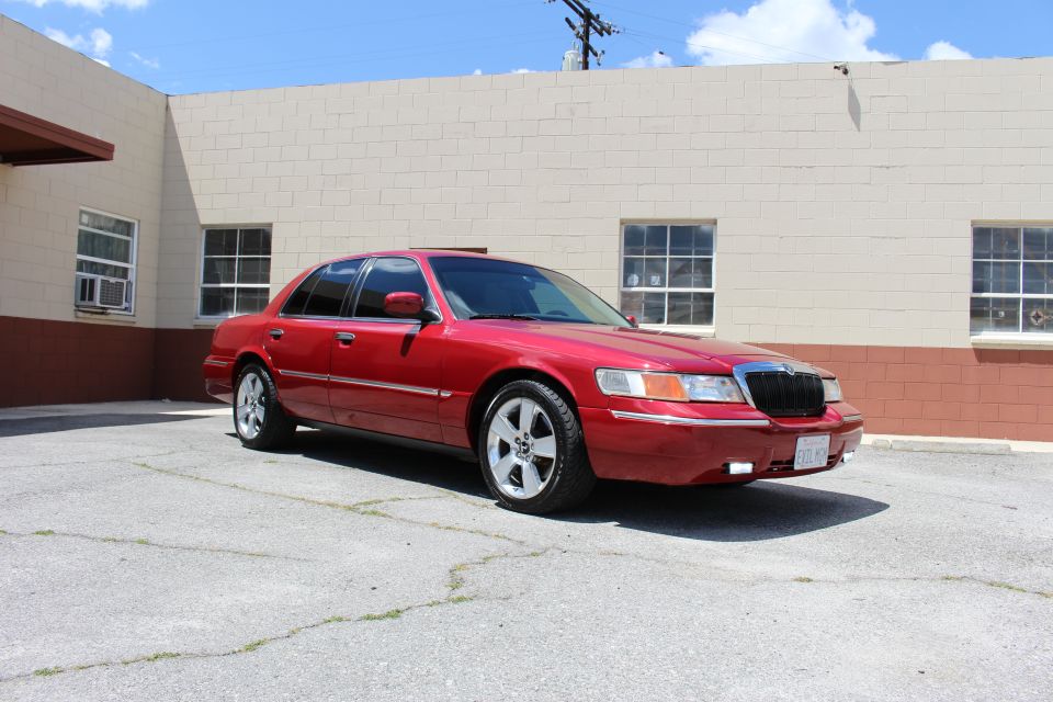 Red 2002 Mercury Grand Marquis parked in a lot. Front quarter view