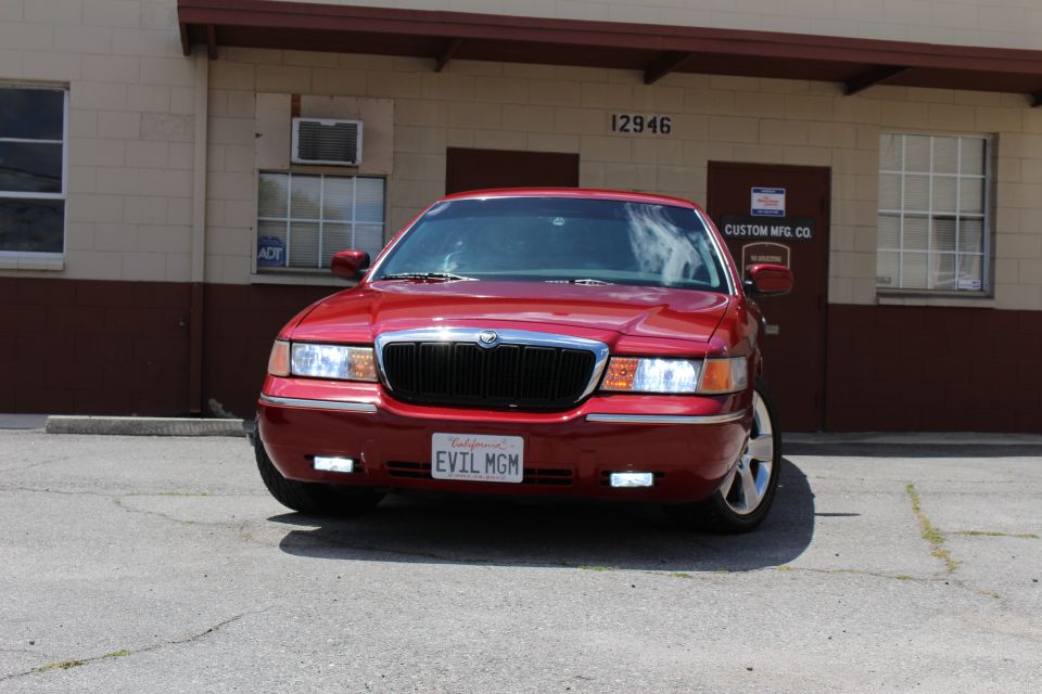Red 2002 Mercury Grand Marquis front view with custom license plate "EVIL MGM"