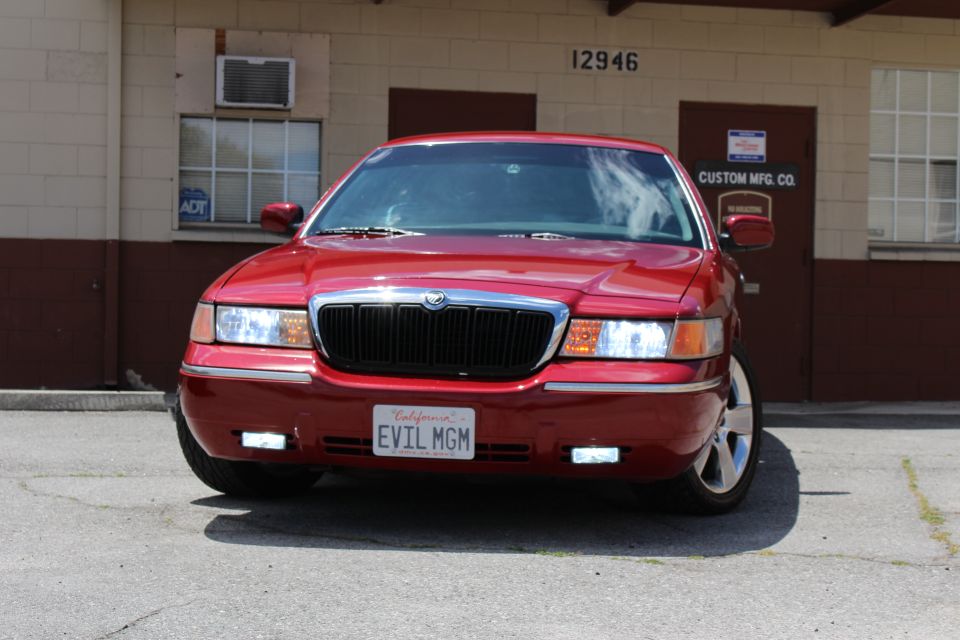 Red 2002 Mercury Grand Marquis front view, license plate reads EVIL MGM
