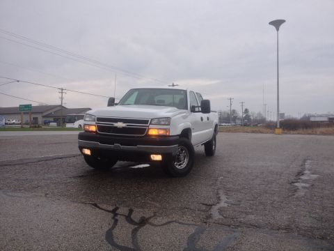 2006 Chevrolet Silverado 2500 - Front 3/4 view of a white 2006 Chevrolet Silverado 2500 pickup truck on a cloudy day.