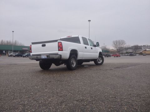 2006 Chevrolet Silverado 2500 - A white pickup truck is parked in a lot on an overcast day. The truck appears to be a 2006 Chevrolet Silverado 2500.