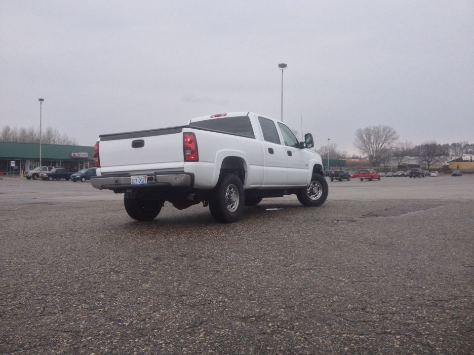 White crew cab pickup truck parked in a lot. License plate reads 'DCT 200'