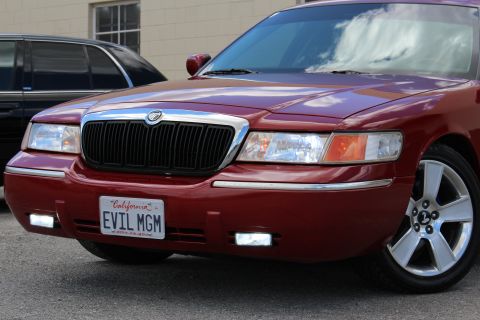 2002 Mercury Grand Marquis - Front view of a red 2002 Mercury Grand Marquis, showing the grille, headlights, and license plate.
