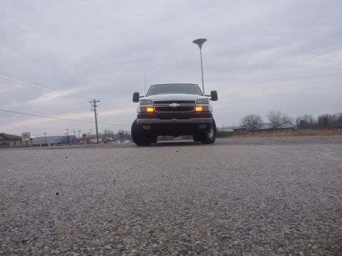 2006 Chevrolet Silverado 2500 - The front of a silver Chevrolet Silverado 2500 is captured under a cloudy sky.