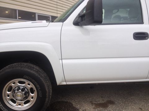 2006 Chevrolet Silverado 2500 - Close-up side view of a white Chevrolet Silverado pickup truck, focusing on the front door and fender area.