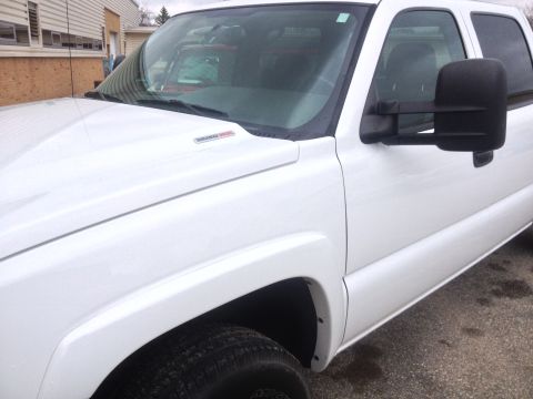 2006 Chevrolet Silverado 2500 - Close-up of a white pickup truck's fender, showing a Duramax Diesel badge. The truck appears to be from around 2006.