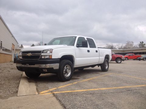 2006 Chevrolet Silverado 2500 - A white 2006 Chevrolet Silverado 2500 pickup truck is parked in a lot with other vehicles visible in the background.