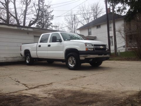 2006 Chevrolet Silverado 2500 - A white 2006 Chevrolet Silverado 2500 is parked in front of a house and garage.