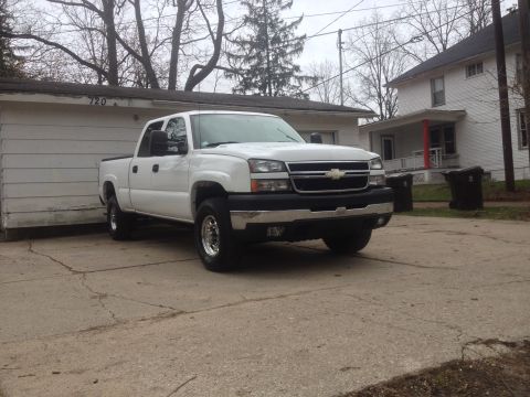 2006 Chevrolet Silverado 2500 - White Chevrolet Silverado pickup truck parked in front of a garage.