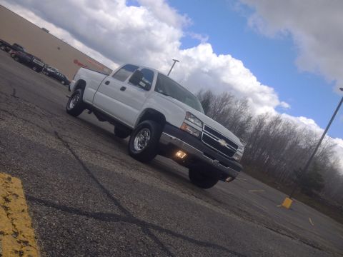 2006 Chevrolet Silverado 2500 - This white 2006 Chevrolet Silverado 2500 is captured in a three-quarter front view, its grille and front end.