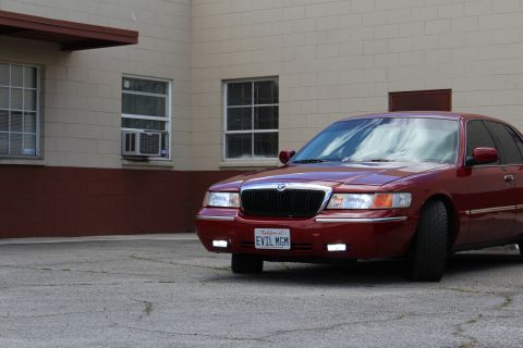 2002 Mercury Grand Marquis - Red 2002 Mercury Grand Marquis parked in front of a building with an air conditioner in the window.