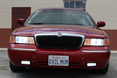 2002 Mercury Grand Marquis - Front view of a red 2002 Mercury Grand Marquis, showing its grille and headlights.