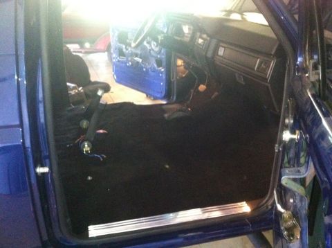 1982 Ford Bronco - Interior of a blue vehicle, possibly a Ford Bronco, with the door open and interior components visible.