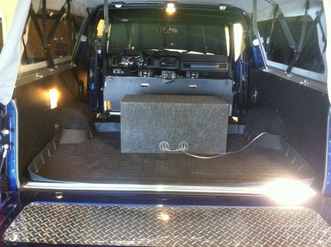 1982 Ford Bronco - The interior of a 1982 Ford Bronco is visible, the dashboard and cargo area with a large speaker box installed.