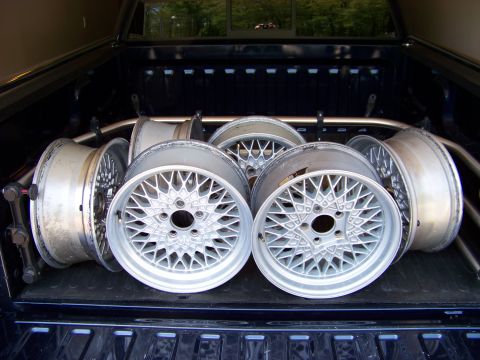 1999 Mercury Grand Marquis - Several mesh alloy wheels are loaded into the bed of a pickup truck.