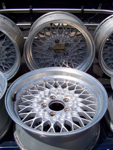 1999 Mercury Grand Marquis - Aftermarket mesh wheels are stacked in the back of a truck, ready for transport or sale.