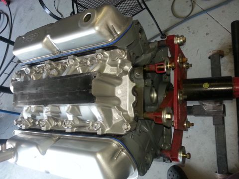 1994 Ford Bronco - A V8 engine with silver valve covers and a red mounting bracket is shown on a stand.
