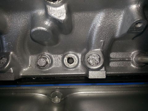 1994 Ford Bronco - Detail of an engine block, showing bolts and a threaded opening.