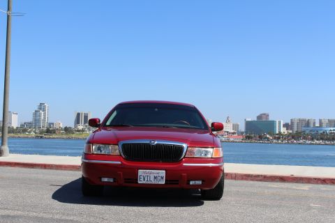 2002 Mercury Grand Marquis - Front view of a red 2002 Mercury Grand Marquis with a custom 'EVIL MGM' license plate.