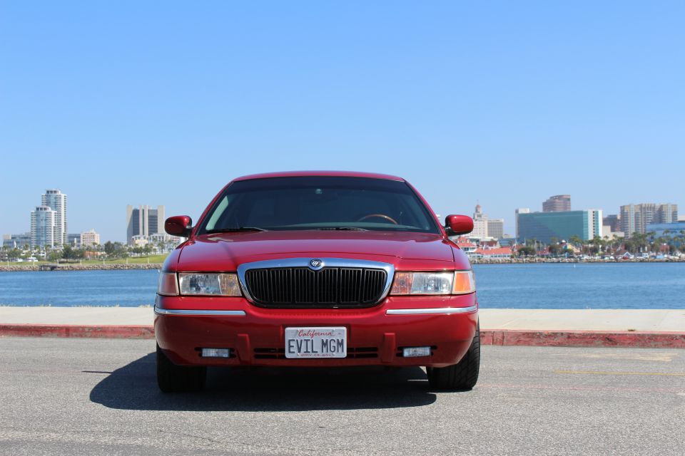 Red 2002 Mercury Grand Marquis parked by the water, front view