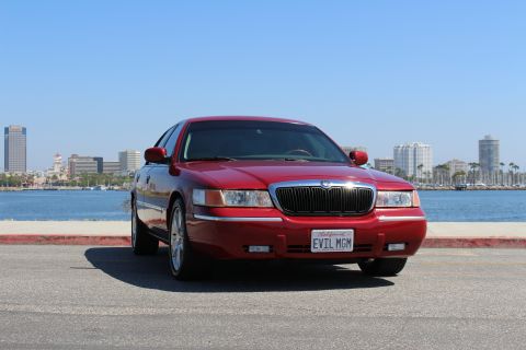 2002 Mercury Grand Marquis - Front view of a red 2002 Mercury Grand Marquis sedan with a custom license plate.