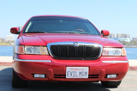 2002 Mercury Grand Marquis - Front view of a red 2002 Mercury Grand Marquis parked by the water.