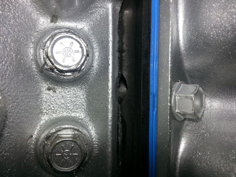 1994 Ford Bronco - Detail of engine components, including bolts and a blue gasket, with Supermotors.net watermark.