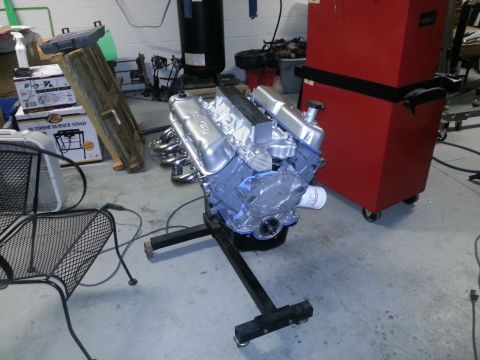 1994 Ford Bronco - Engine on a stand in a garage setting, with tools and storage in the background.
