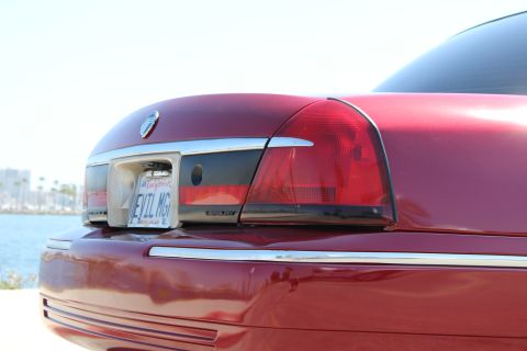 2002 Mercury Grand Marquis - Rear of a red 2002 Mercury Grand Marquis parked near the water.