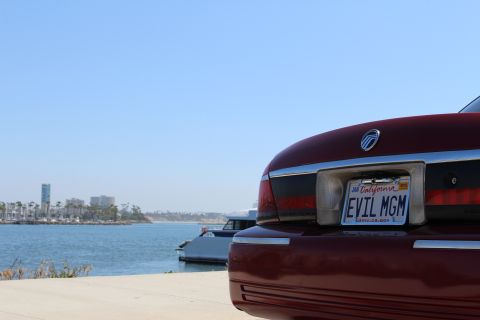 2002 Mercury Grand Marquis - Red 2002 Mercury Grand Marquis parked by the water with a city skyline in the background.