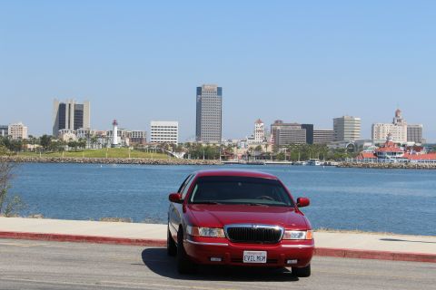 2002 Mercury Grand Marquis - 2002 Mercury Grand Marquis parked by the water with a city skyline behind it.