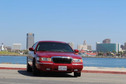 2002 Mercury Grand Marquis - Red 2002 Mercury Grand Marquis parked by the water with a city skyline in the background.