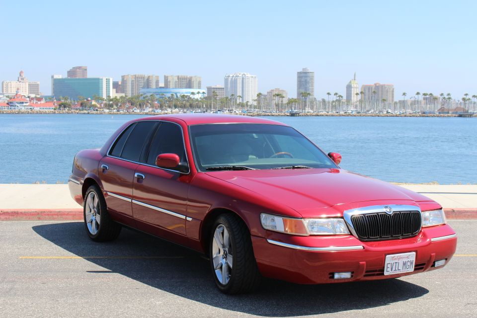 Red 2002 Mercury Grand Marquis parked by the water