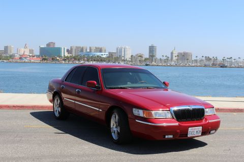 2002 Mercury Grand Marquis - 2002 Mercury Grand Marquis parked by the water with a city skyline in the background.