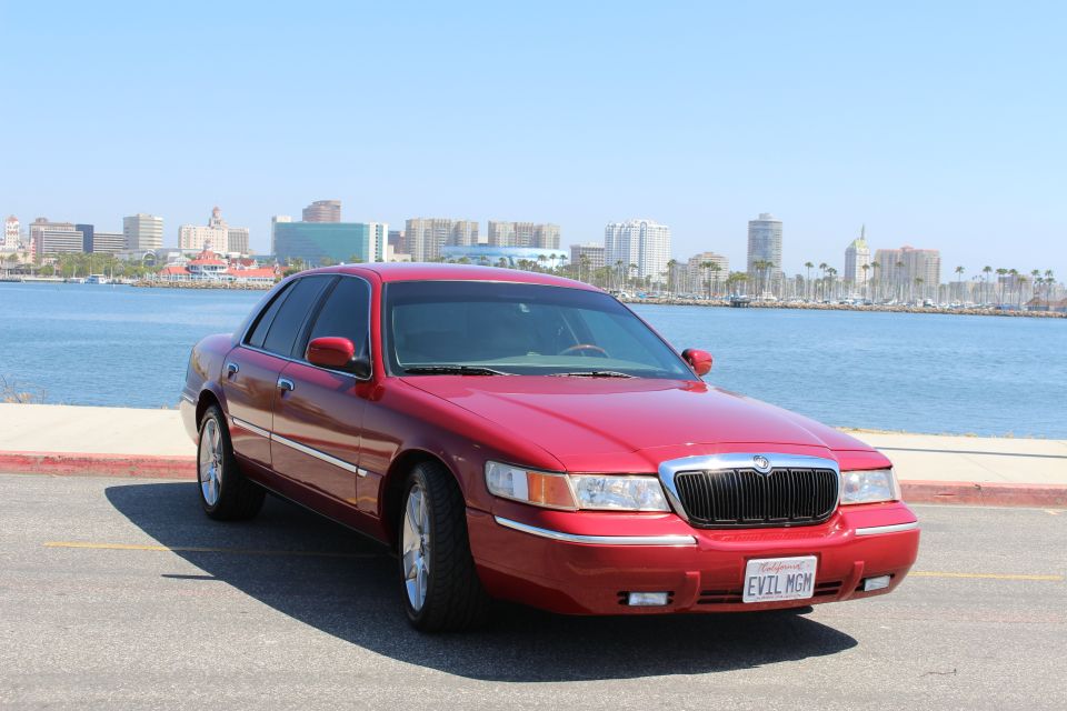 Red 2002 Mercury Grand Marquis parked by the water