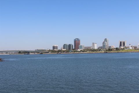2002 Mercury Grand Marquis - A wide shot shows a city skyline across a body of water under a clear blue sky.