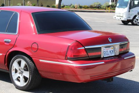 2002 Mercury Grand Marquis - Rear view of a red 2002 Mercury Grand Marquis with tinted windows and a custom license plate.