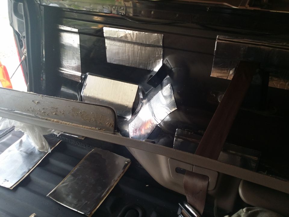 Vehicle interior rear area with soundproofing material applied to panels