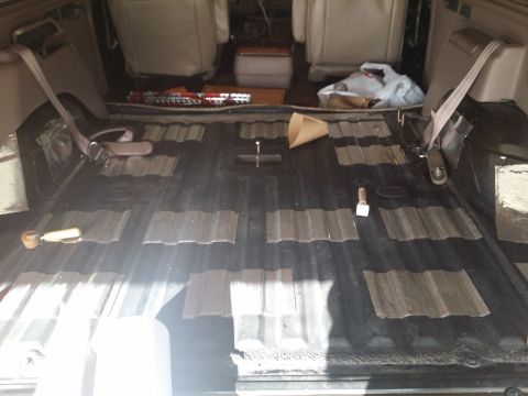 1994 Ford Bronco - The interior of a vehicle is shown with soundproofing material being applied to the floor.
