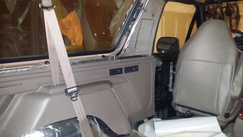 1994 Ford Bronco - The interior of a Ford Bronco shows exposed soundproofing and a removed door panel, suggesting modifications or repairs.