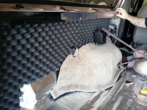 1994 Ford Bronco - Soundproofing foam and insulation are being installed in the rear of a vehicle.