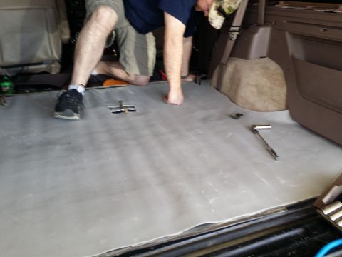 1994 Ford Bronco - Installing soundproofing material in the floor of a vehicle's interior.
