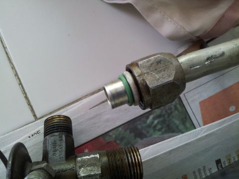 1976 Ford Ranchero - A close-up view of a vehicle's air conditioning hose fitting, showing a green o-ring seal.