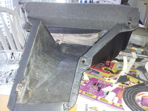 1976 Ford Ranchero - Disassembled car AC evaporator case, possibly from a 1976 Ford Ranchero, sits on a table with newspapers and tape.