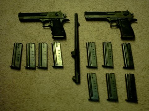 1995 Ford Bronco - Two handguns and eight magazines are arranged on a carpeted floor.