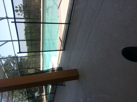 1994 Ford Bronco - A view of a swimming pool area, a screened enclosure and a wooden beam in the foreground.