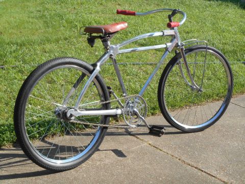 Chrome frame bicycle with brown leather seat and red handlebars