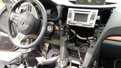 2014 Subaru Outback - Dashboard disassembly in a 2014 Subaru Outback, exposing wiring behind the stereo unit.